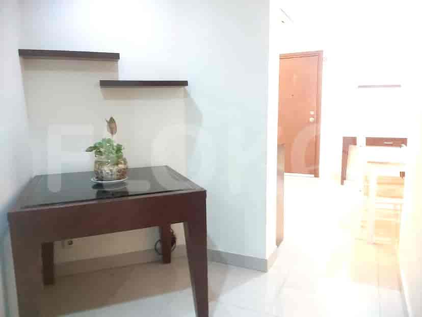 An entrance featuring a decorative table with a potted plant.
