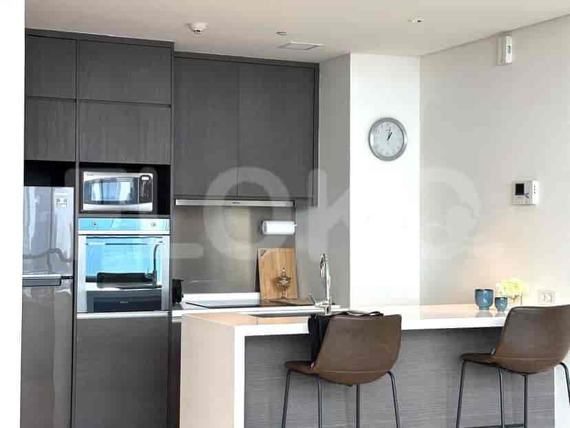 A modern kitchen setup with a microwave, oven, and cabinetry. Features a kitchen bar with stools.