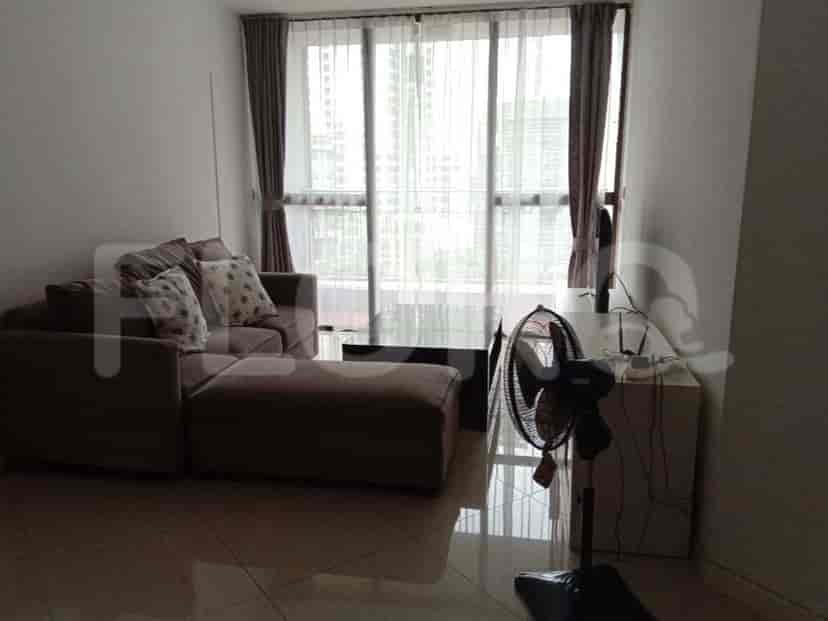 A modern living room with a grey L-shaped sofa and a city view.