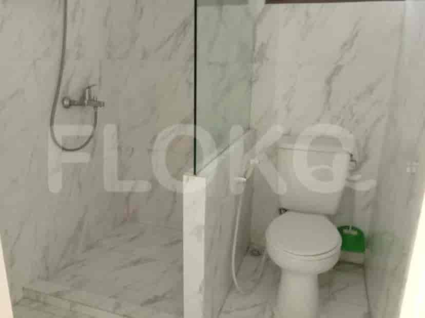 A modern bathroom with a glass shower and a toilet.