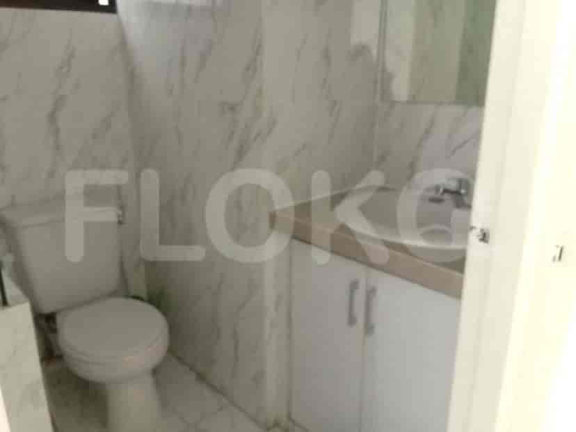 A small bathroom with white tiles and a sink.