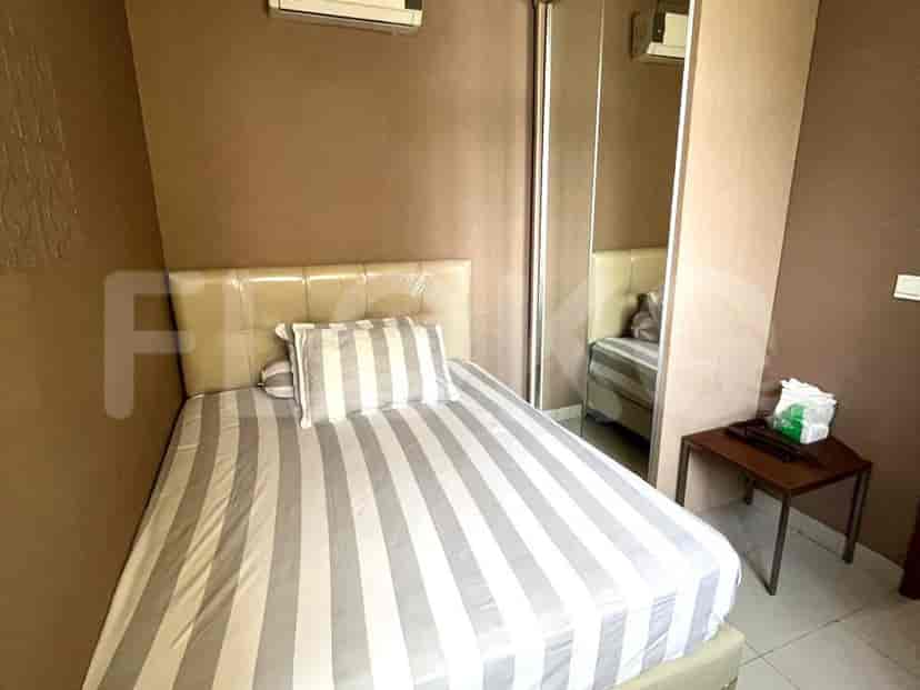 A cozy bedroom with a striped bedspread, mirrored closet, and simple decor.