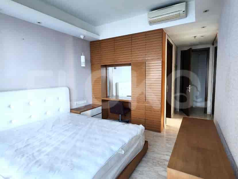 Kamar tidur dengan dua tempat tidur single dan dinding hijau.