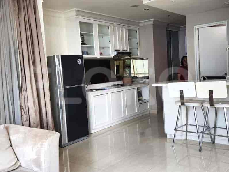 Kitchen and a living room area with white cabinets and a large refrigerator.