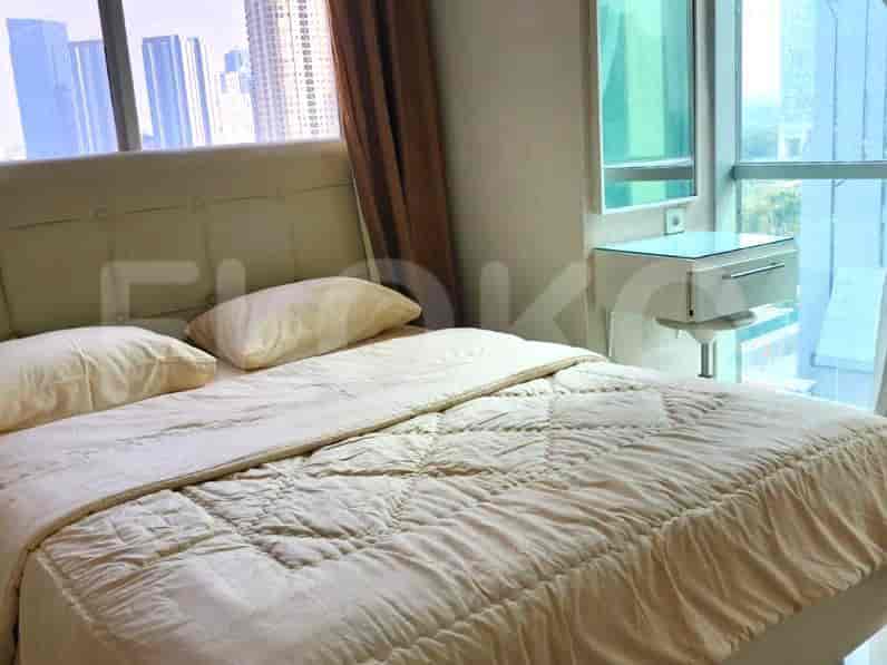A bedroom with a queen-sized bed, curtains, and a city view.