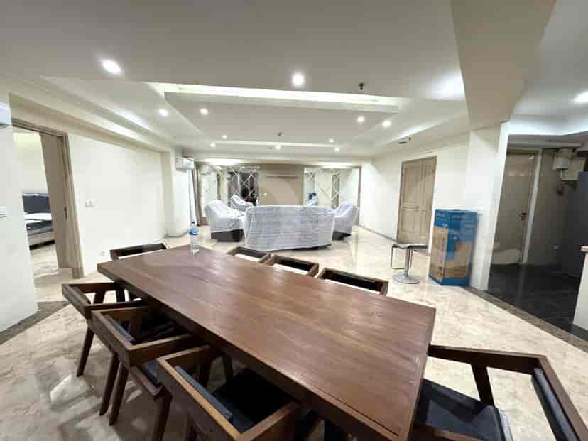 Living and dining areas featuring a large wooden table and covered furniture.