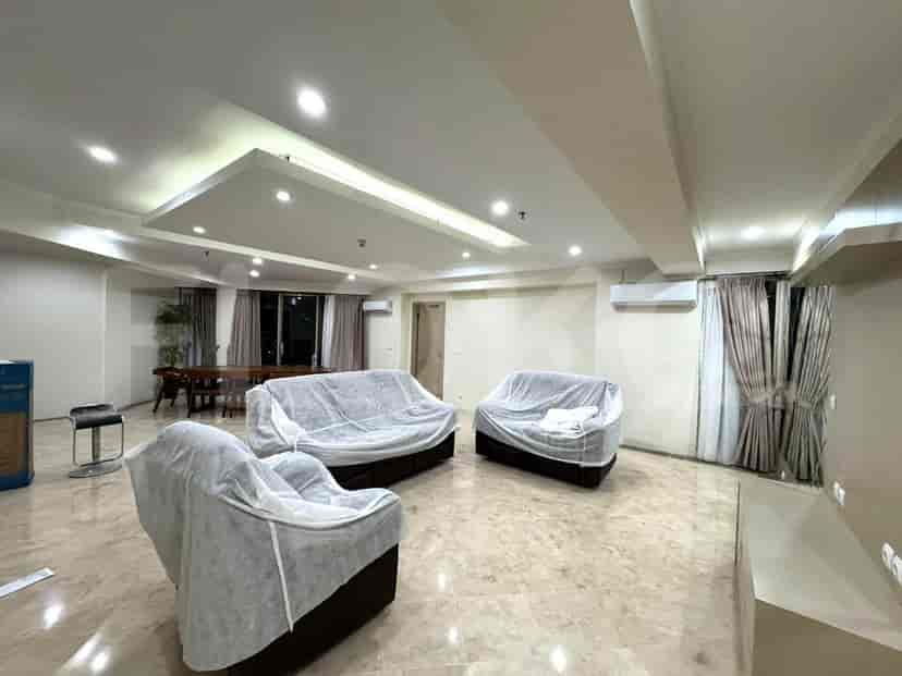 Spacious living room with covered furniture, marble flooring, and recessed lighting.