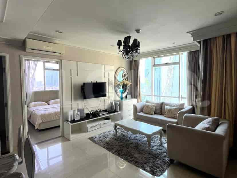 A well-lit living room with a cream-colored sofa, a coffee table, and a mounted TV.