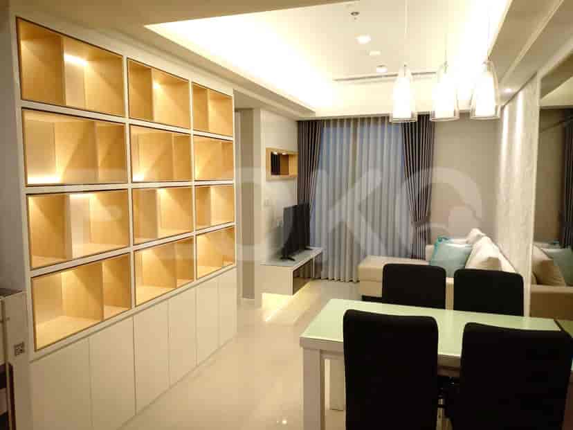 Living and dining area featuring a large cabinet, dining table with black chairs, and hanging lights.