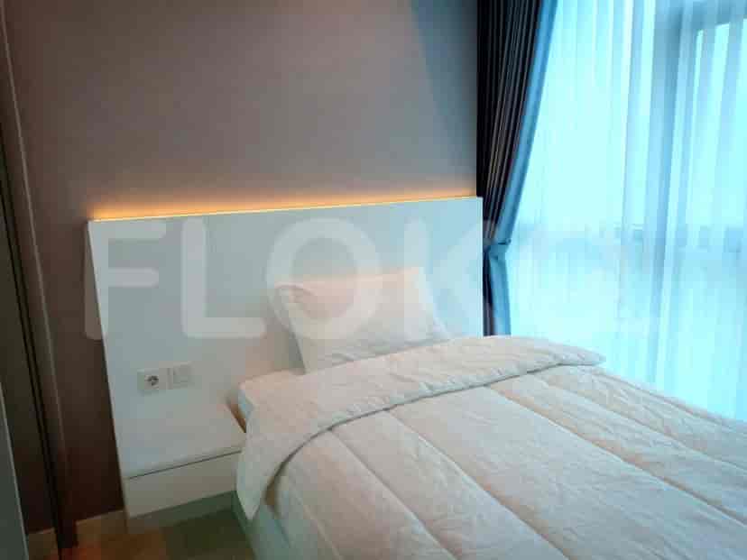 A bedroom with a minimalist design, featuring a bed with a simple headboard.