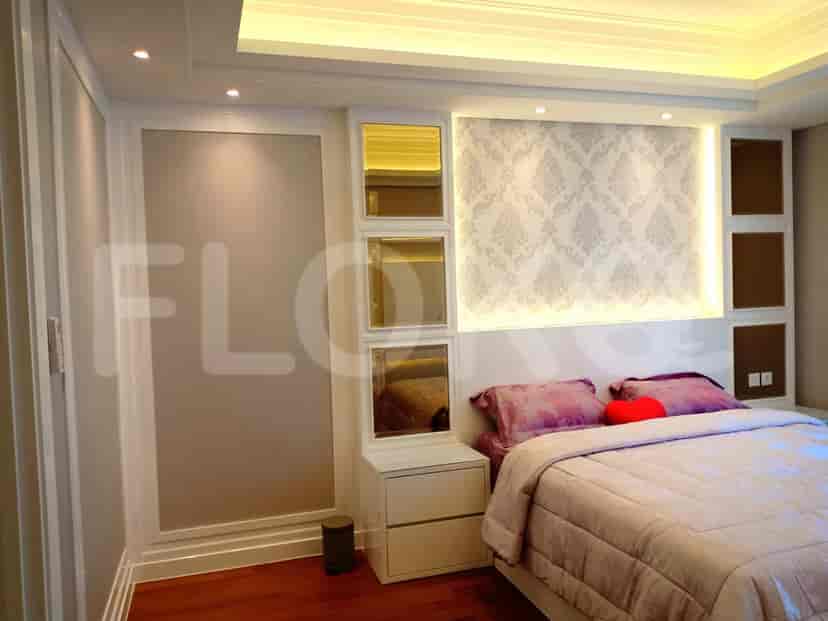 Kamar tidur modern dengan tempat tidur, dinding dekoratif, dan aksen bercermin.