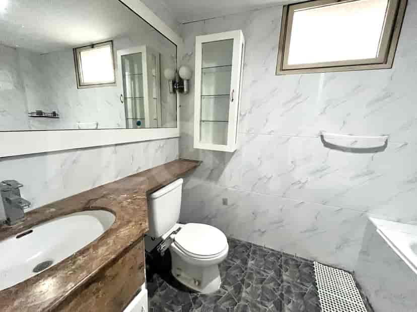 Bathroom with a sink, toilet, and tiled walls.