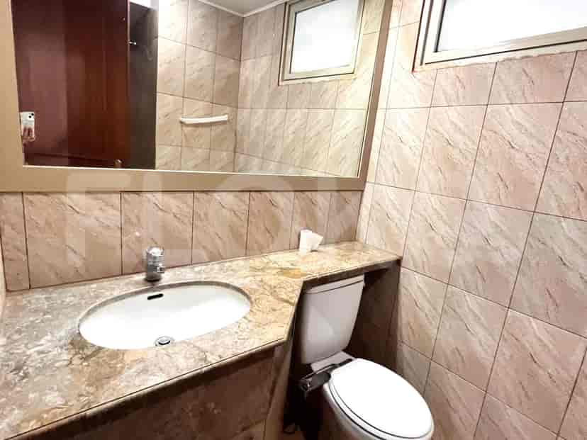 Bathroom with a toilet, sink, and a mirror.