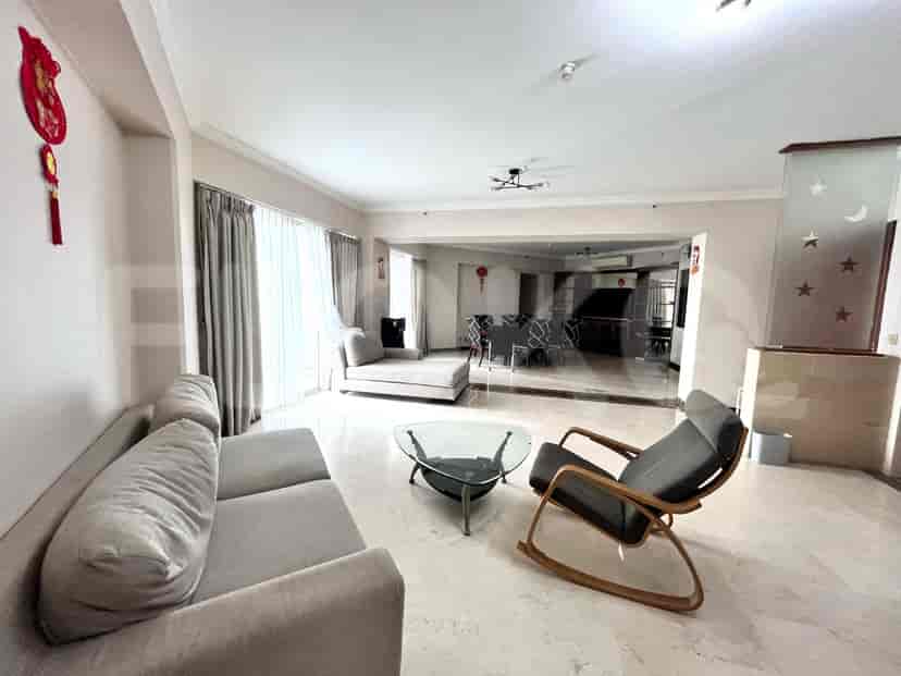 Spacious living room with a grey sofa, glass coffee table, and a view through the sliding glass doors.