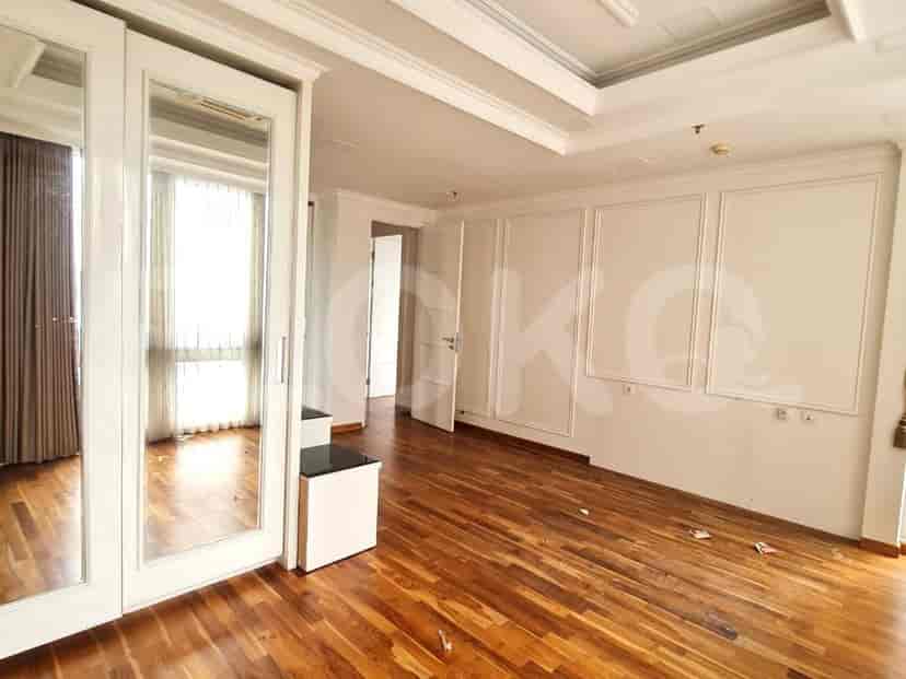 Empty bedroom with wooden floor and white accents.
