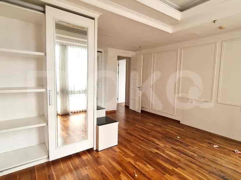 Bedroom with large windows, wooden floor, and closet.