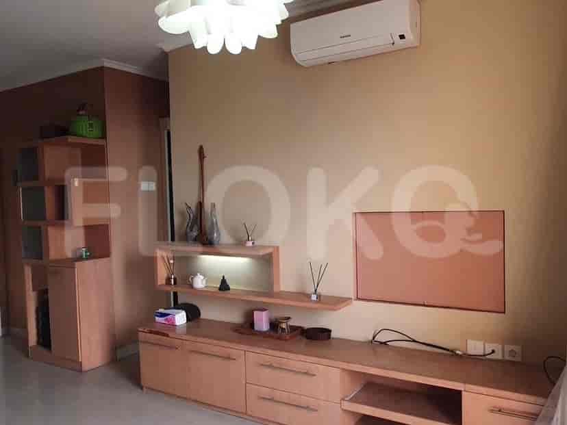 Living room with built-in storage, wall-mounted decor, and a kitchen area visible.