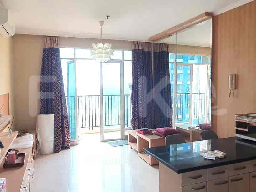 Living room with a balcony access. Features include curtains and a light fixture.