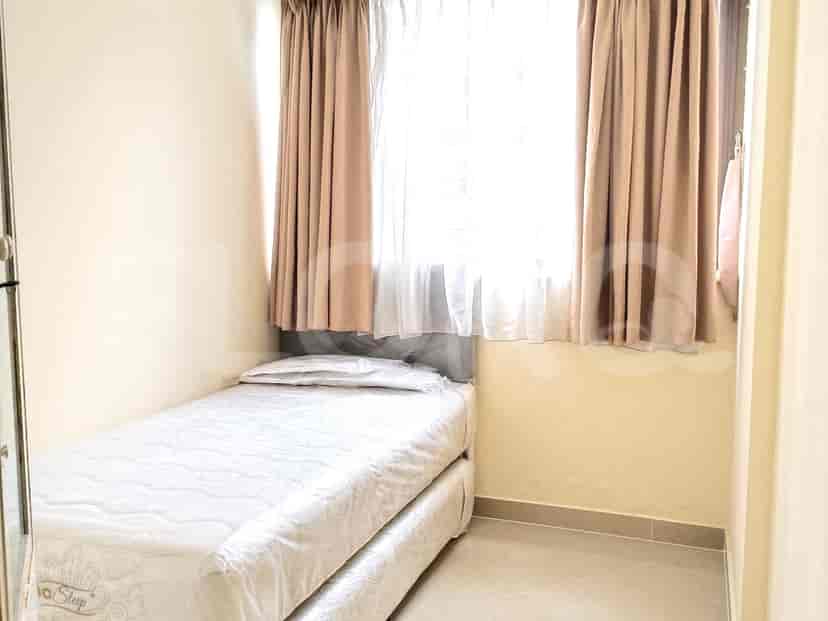 Small bedroom with a single bed and curtains.