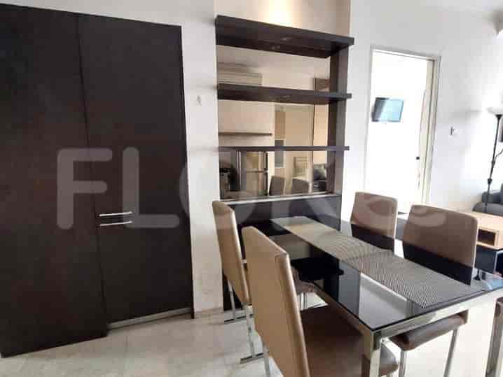 Dining area with a glass-top dining table, four chairs, and a dark wooden cabinet.