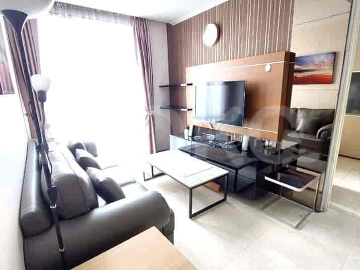 A modern living room with an L-shaped grey sofa, a wall-mounted TV, and a coffee table.