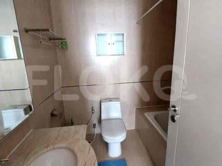 A well-lit bathroom with a vanity, toilet, and bathtub.