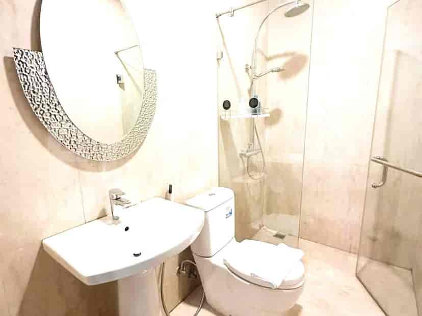 A modern bathroom featuring a walk-in shower, sink, and toilet.