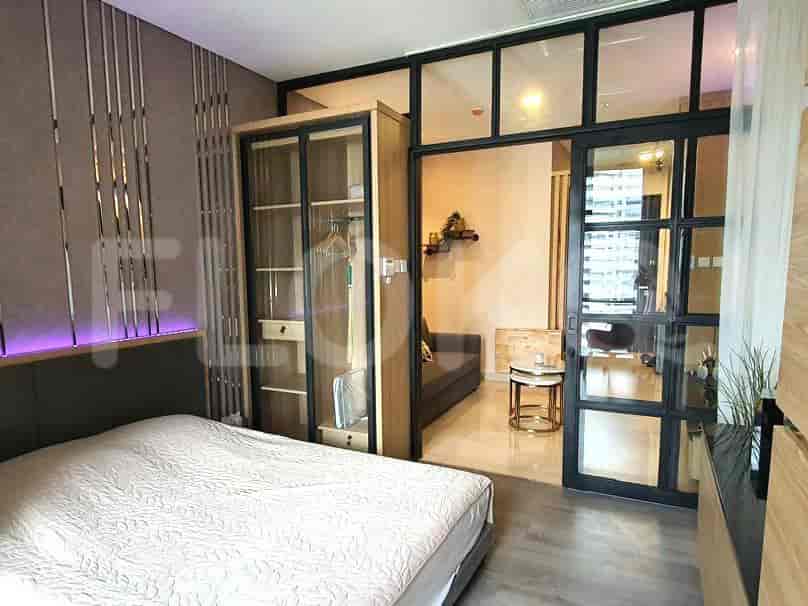 A modern bedroom with a wardrobe, bed, and glass doors.