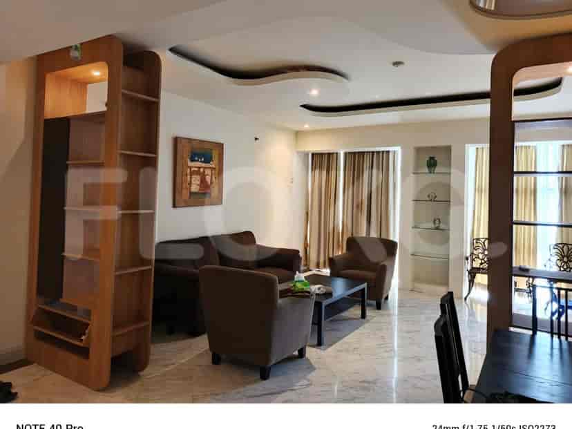 A living room with a brown sofa, armchairs, and a coffee table.