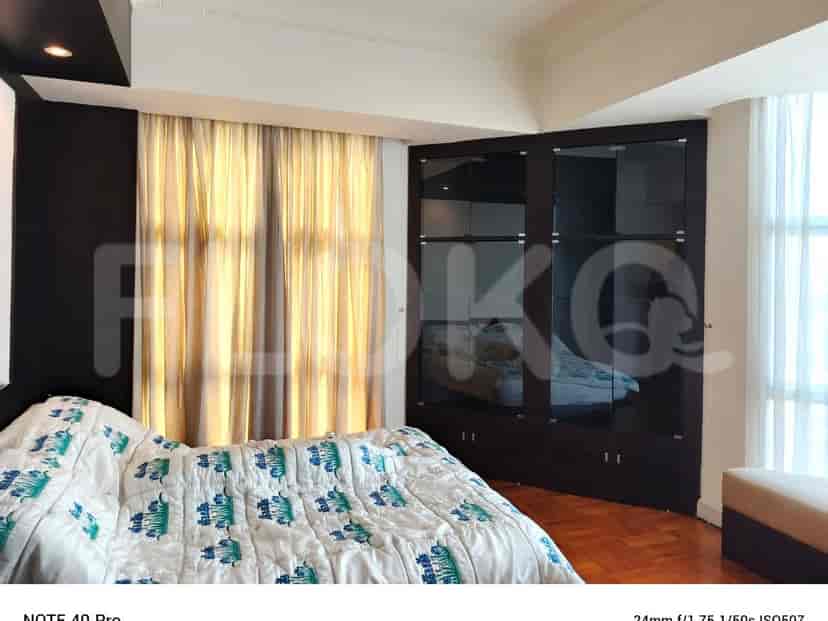 A bedroom with a bed, curtains, and a built-in closet.