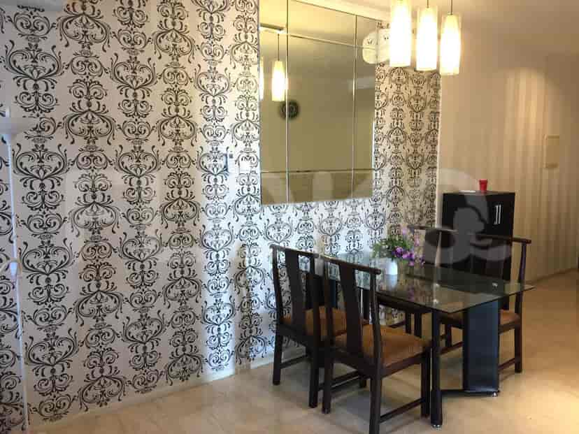 Area makan dengan meja makan, kursi, dan wallpaper bunga.