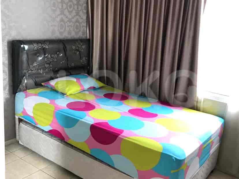 Kamar tidur dengan tempat tidur single dan sprei berwarna-warni.
