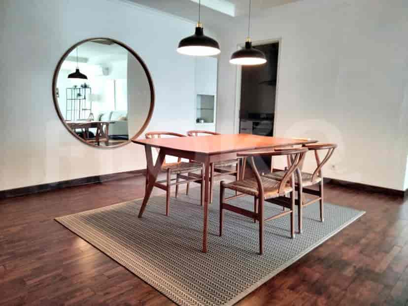 Ruang makan modern dengan meja dan kursi kayu.