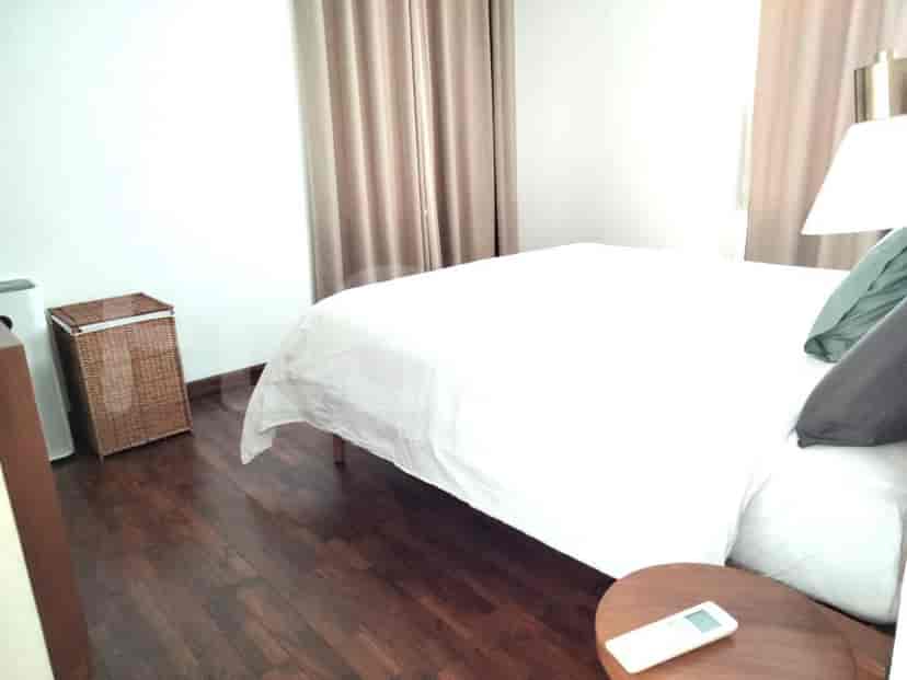 Kamar tidur dengan tempat tidur, meja samping, dan lampu.