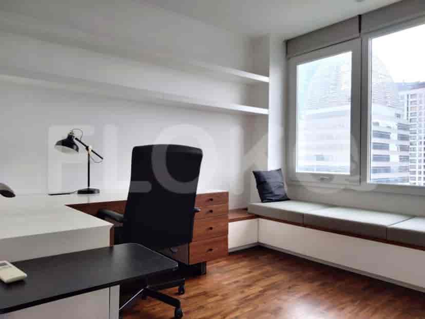 Kantor rumah dengan meja, kursi, dan jendela dengan pemandangan kota.