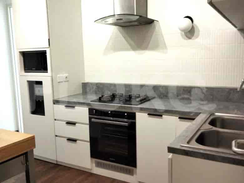 Dapur modern dengan lemari putih, meja abu-abu, dan kompor baja tahan karat.