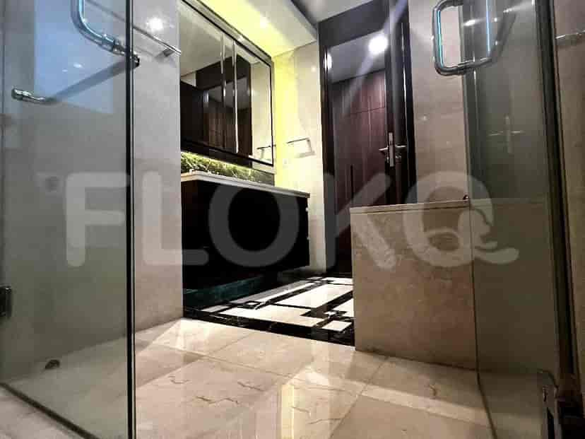 Modern bathroom with glass shower and marble flooring.