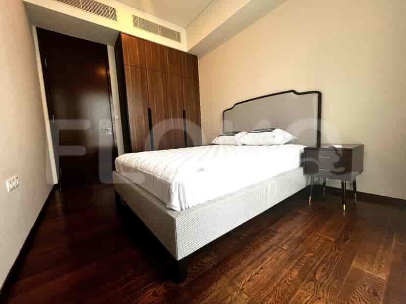 Bedroom with a bed, wooden flooring, and wooden closet.