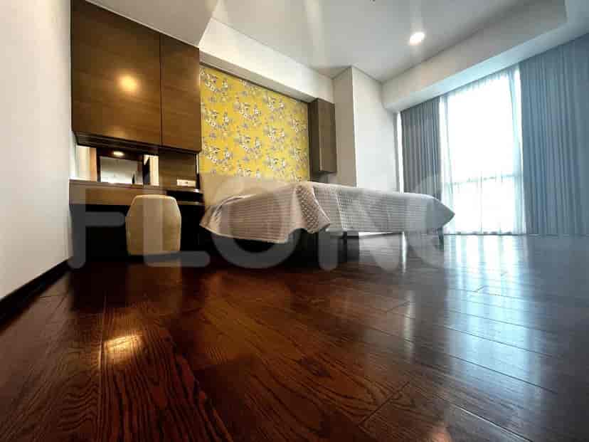 Bedroom with a bed, wooden flooring, and a unique wall design.
