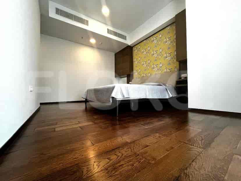 Bedroom with a bed and wooden flooring.