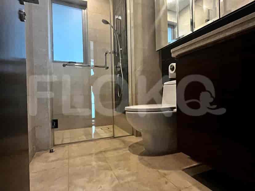 Bathroom with glass shower and marble flooring.