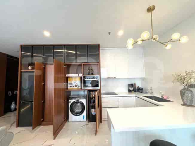 Modern kitchen with white cabinets, a washing machine, and a microwave.