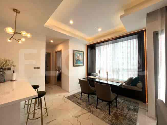 Dining area with a table and chairs, and a glimpse of the kitchen.