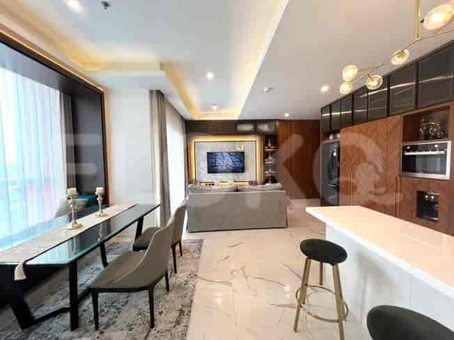 Open-plan living space with a dining table, sofa, and kitchen.