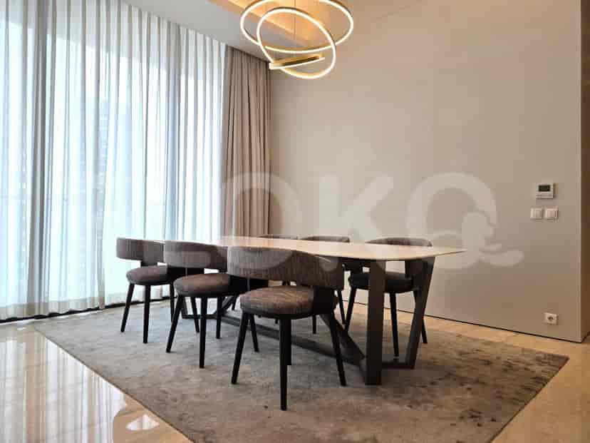 Dining area with a long rectangular table, six chairs, and a stylish chandelier.