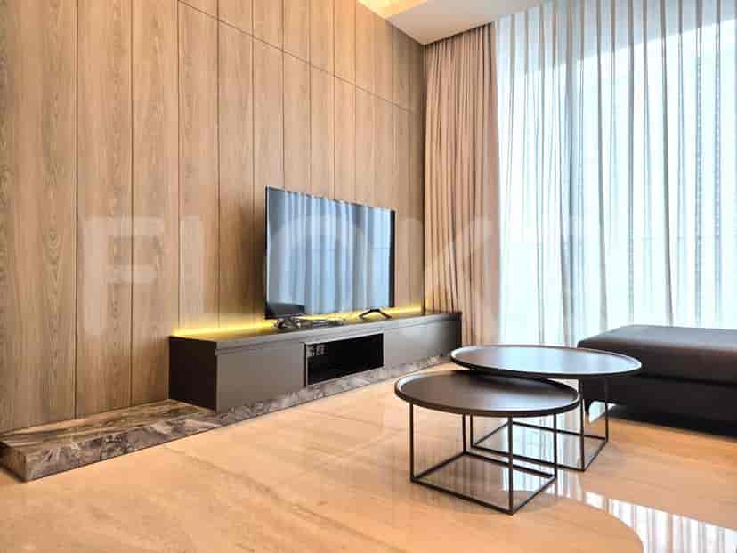 Living room featuring a built-in TV console, flat-screen TV, and a second set of coffee tables.