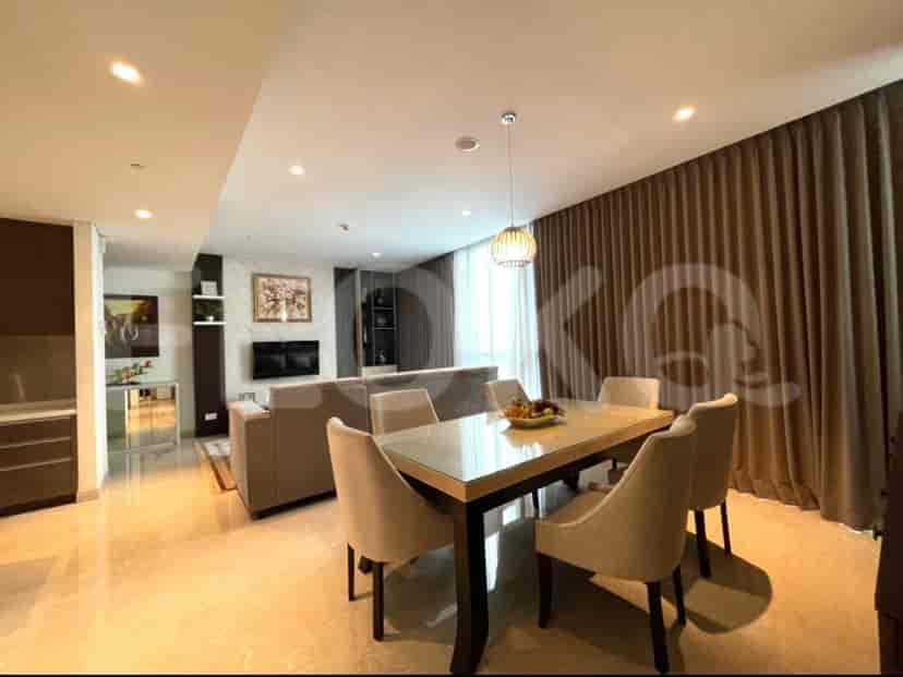 Dining area with a glass-topped table, comfortable chairs, and a large painting.