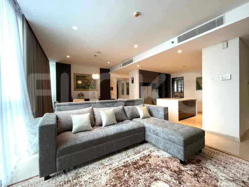 Spacious living room with grey sectional sofa, ornate rug, and open layout.