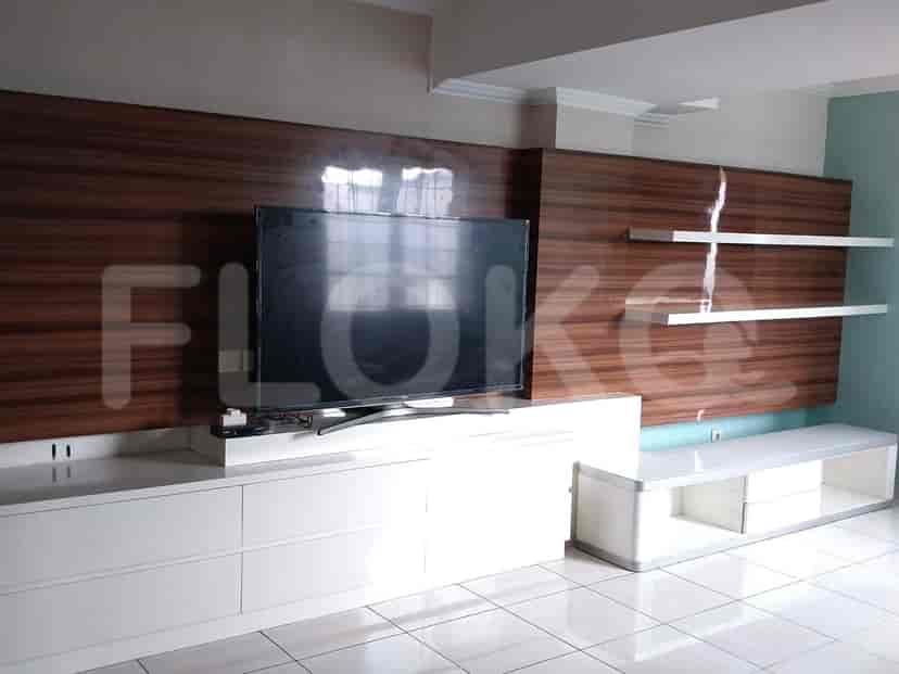 Living room with a TV and an entertainment unit.