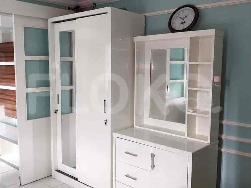 Bedroom with a white wardrobe and mirror.